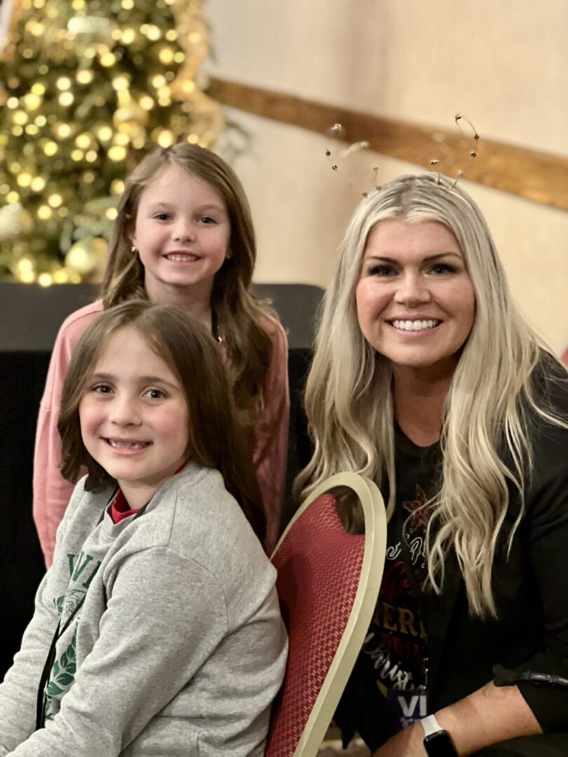 A woman and two girls smiling for the camera.