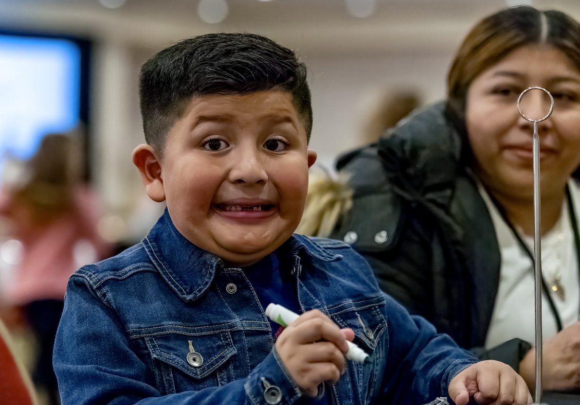 A boy holding a toothbrush in his mouth.